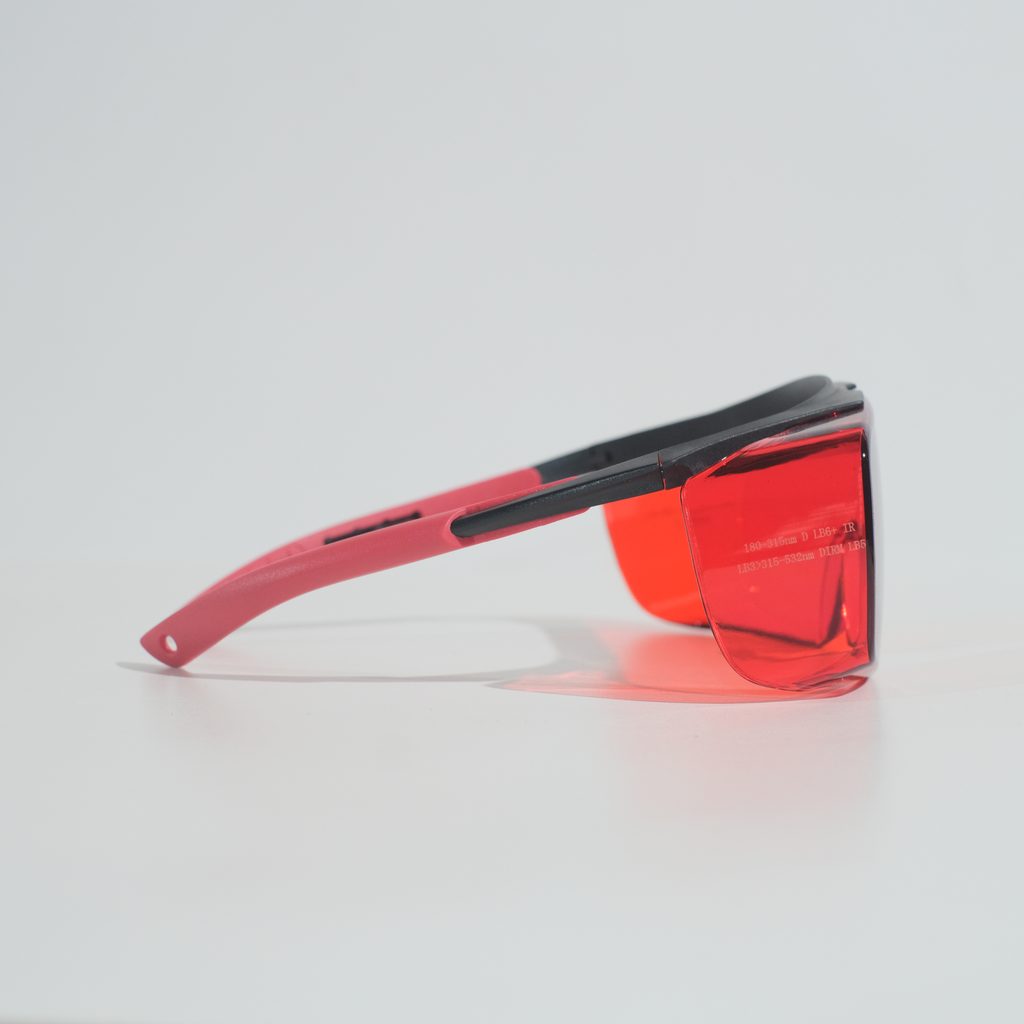 Side profile of the glasses showing the red side shield and the black-and-red adjustable temple arm.